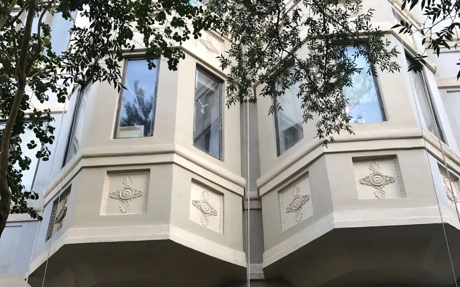 Restored bay windows with plaster medallions on a historic facade